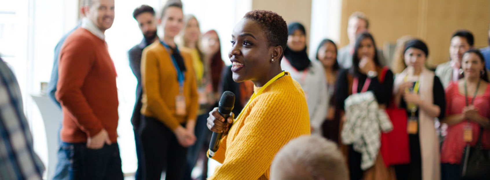 woman with microphone in a crowded room